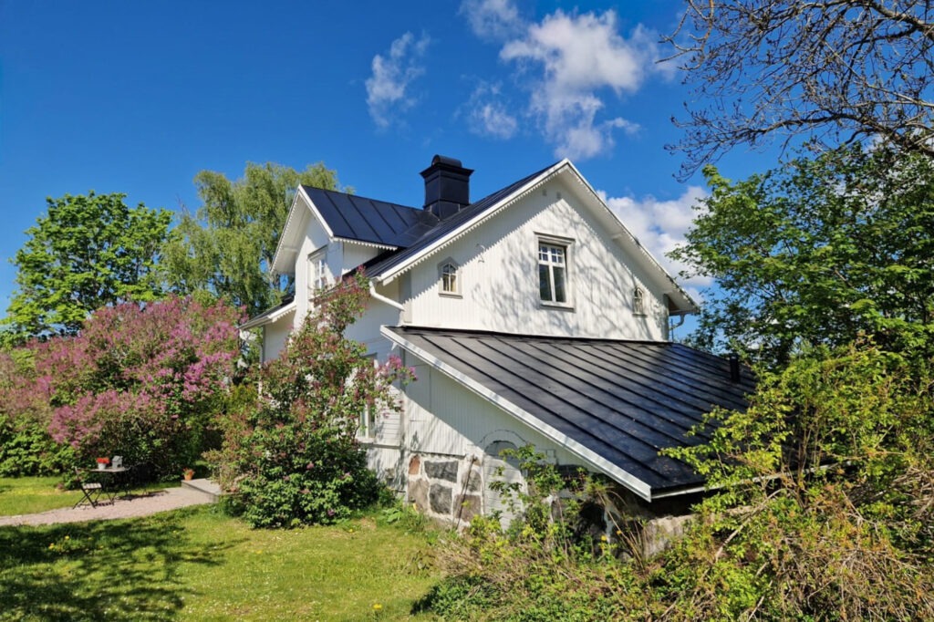 Vit villa med falsat plåttak.