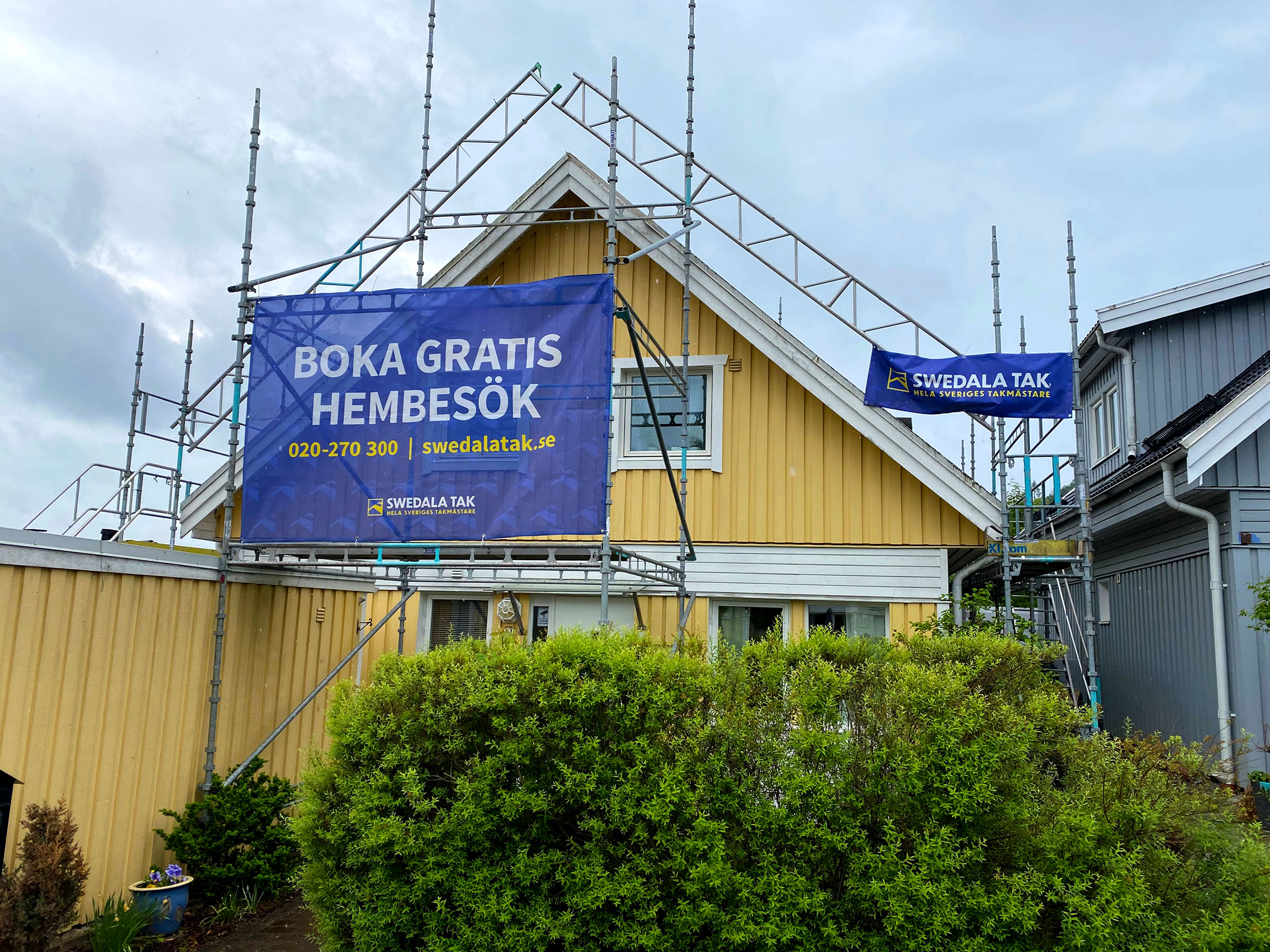 Swedala tak banderoll och byggställning under ett pågående takbyte