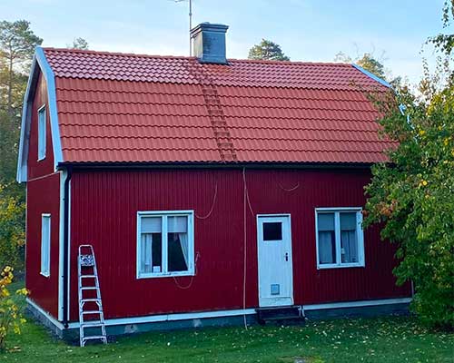 Betongpannor på rött hus med vita knutar
