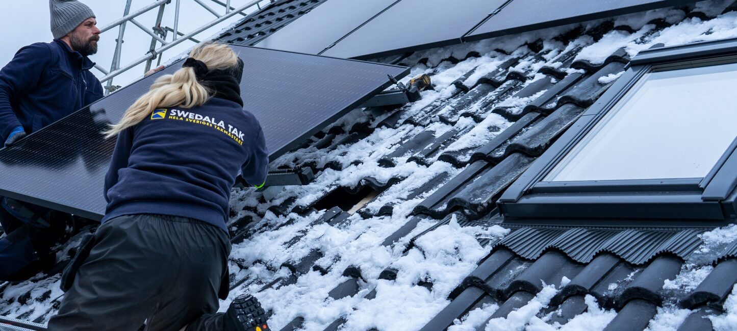Takläggare monterar solpaneler på ett färdigt tak