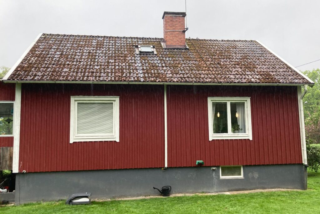 ett rött hus med gammalt tegeltak