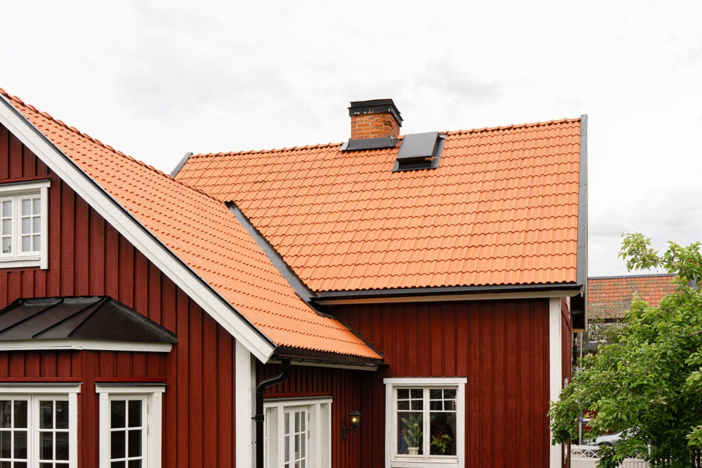 Lertegel på rött trähus.