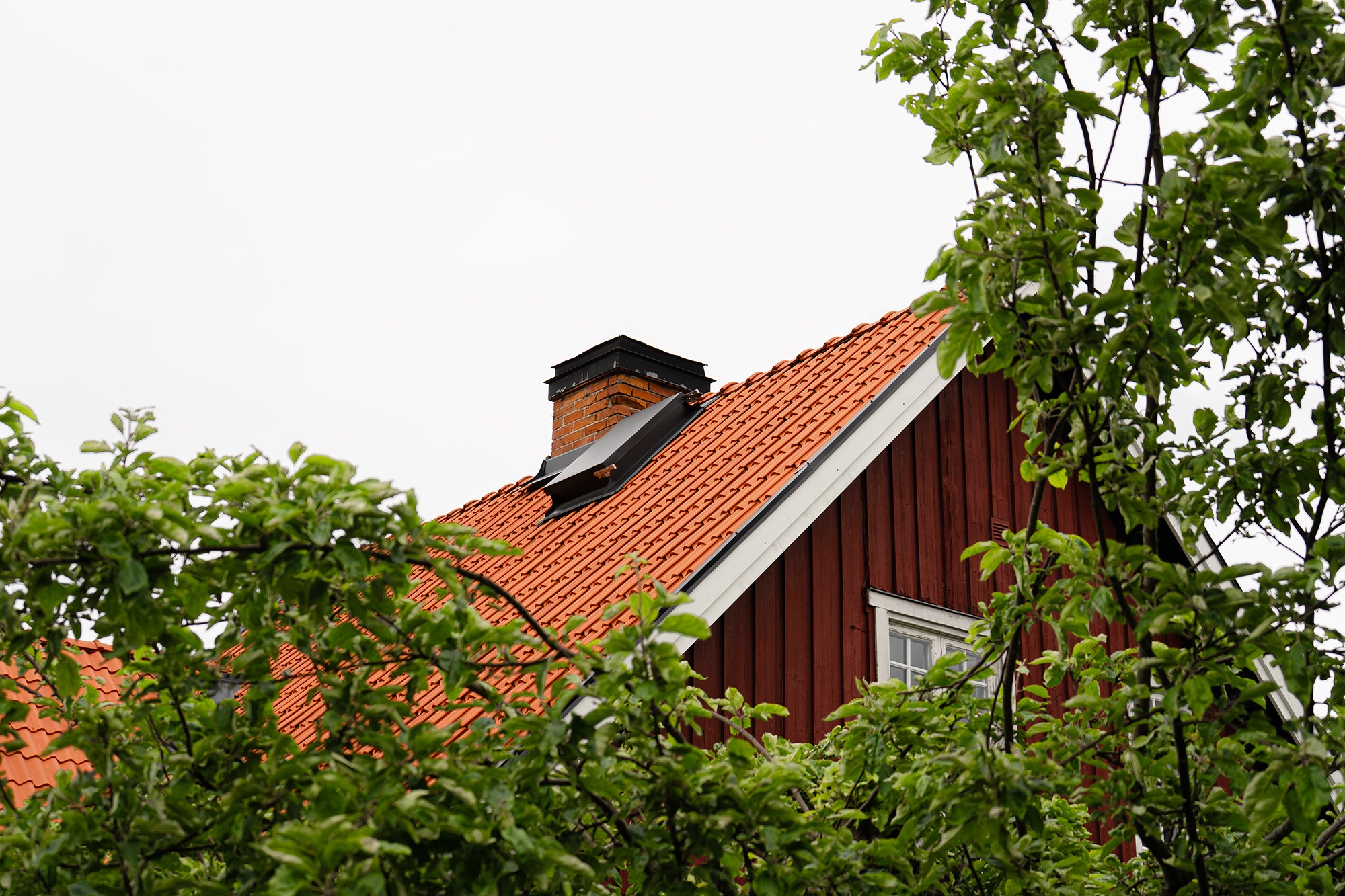 Lertegel på rött trähus.