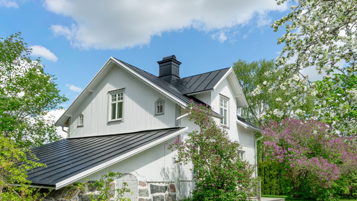 Vit villa med falsat plåttak.