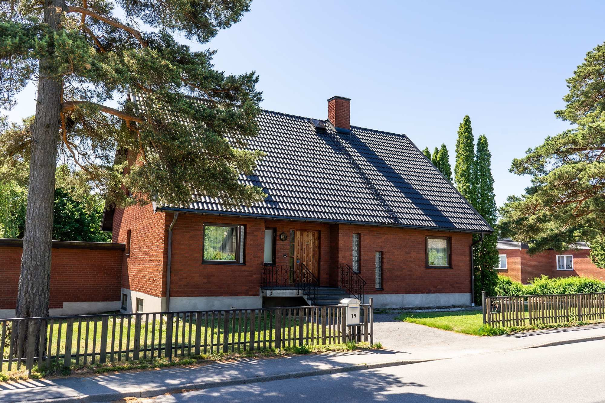 Svart betongtak på tegelhus.