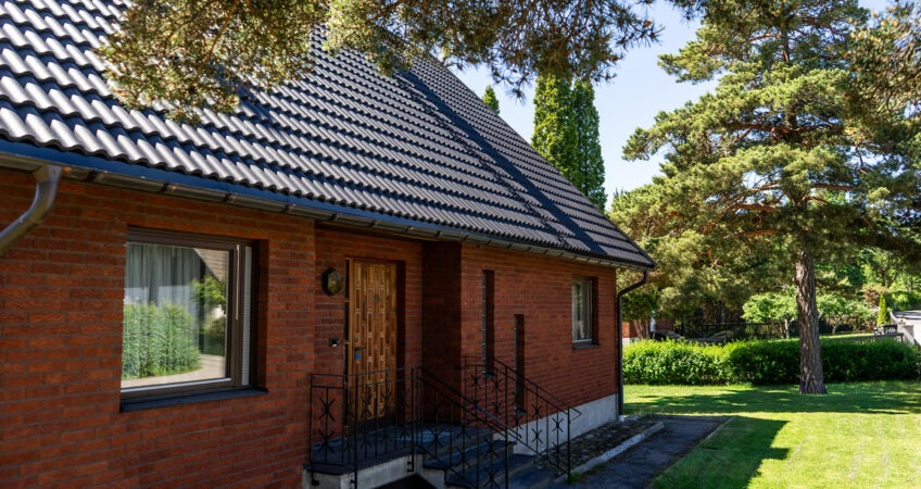 Svart betongtak på tegelhus.